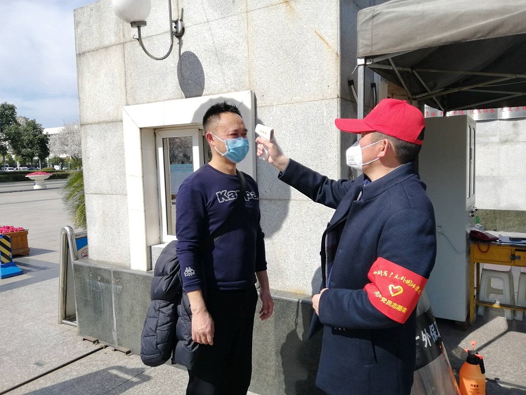 全國五一勞動獎?wù)芦@得者、廣元外國語學(xué)校黨辦主任王軍（右一）在監(jiān)測體溫.jpg